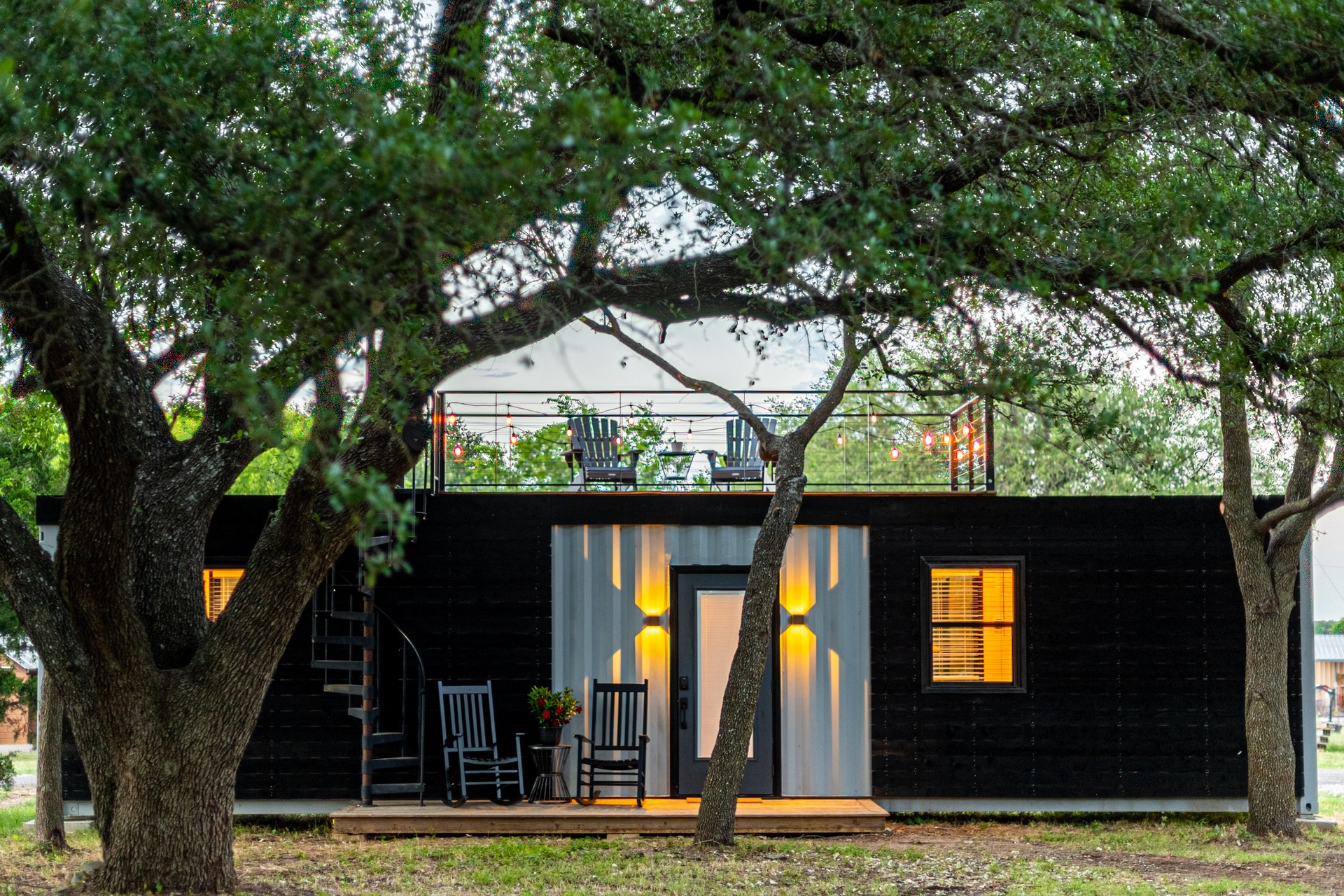 Black tiny house with a roofdeck.