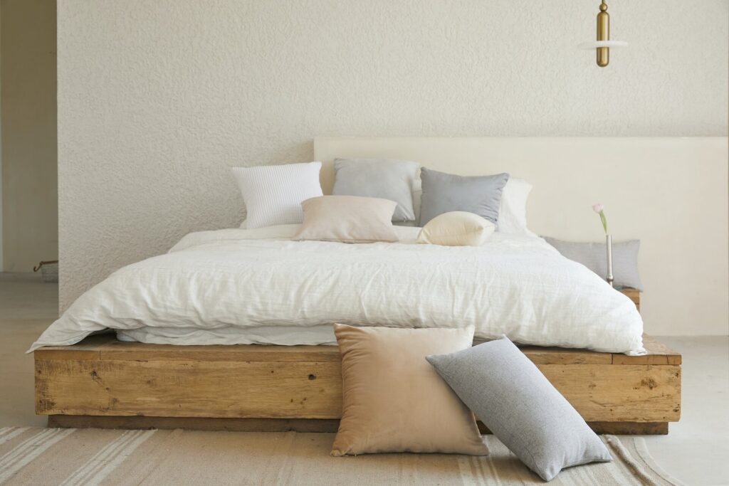 White beddings and pillows on top of a wooden bed