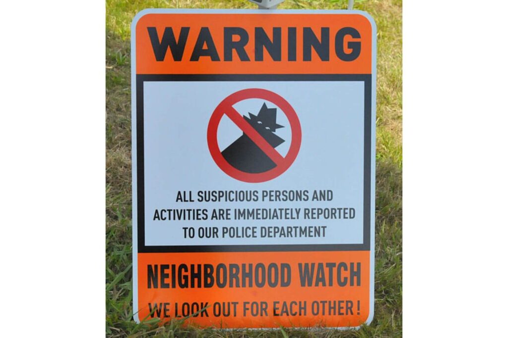 Neighborhood street sign warning would-be criminals about being reported to the police