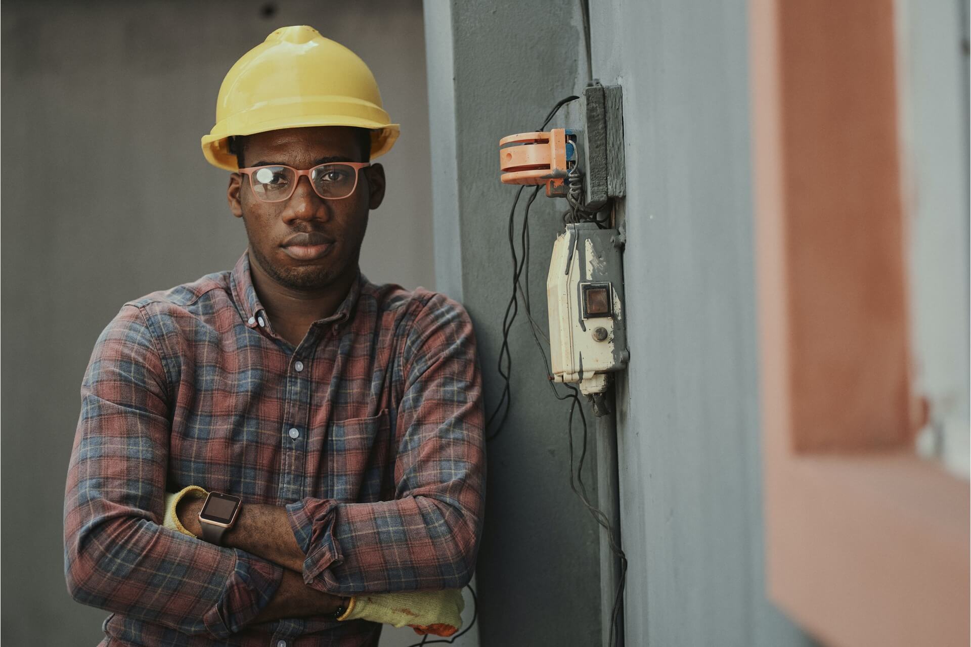 An electrician standing with arms crossed.
