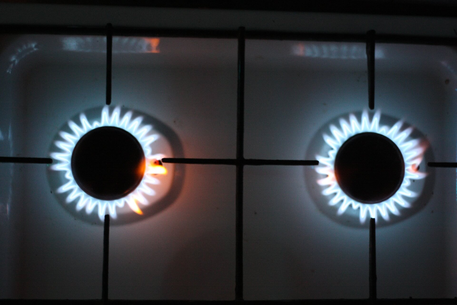 A gas stove with two burners on.