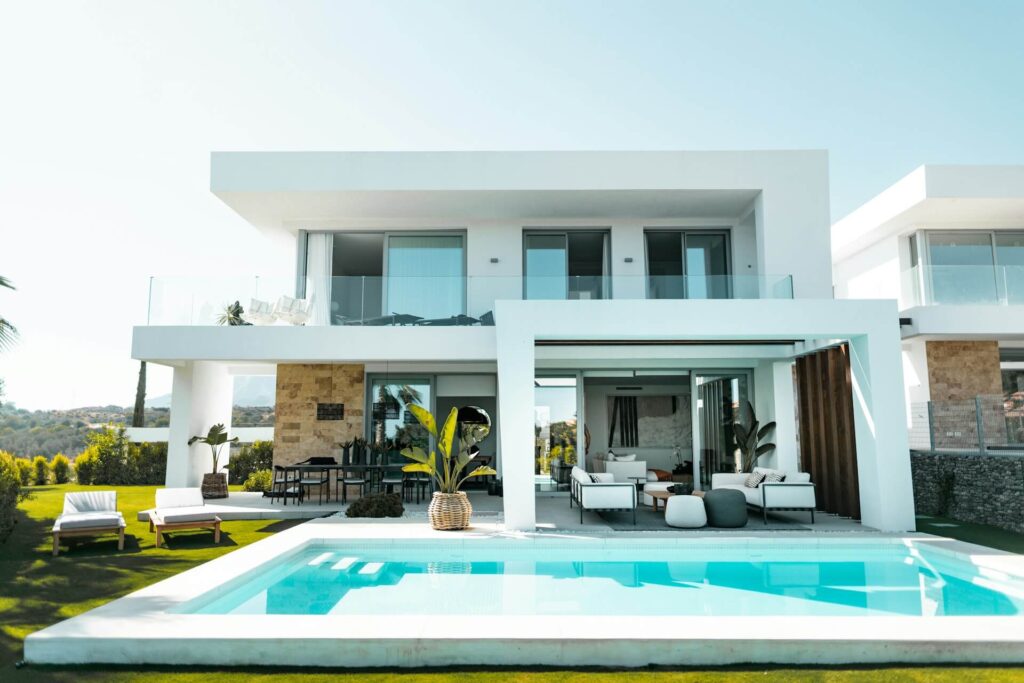White and blue swimming pool in front of a luxury house
