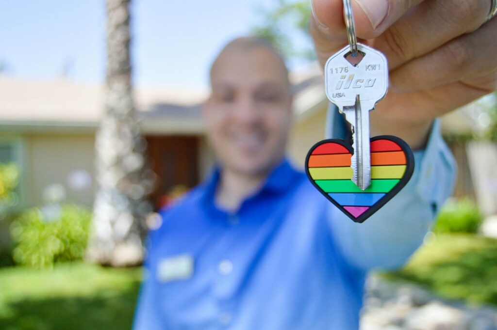 Man holds a house key with a heart key chain