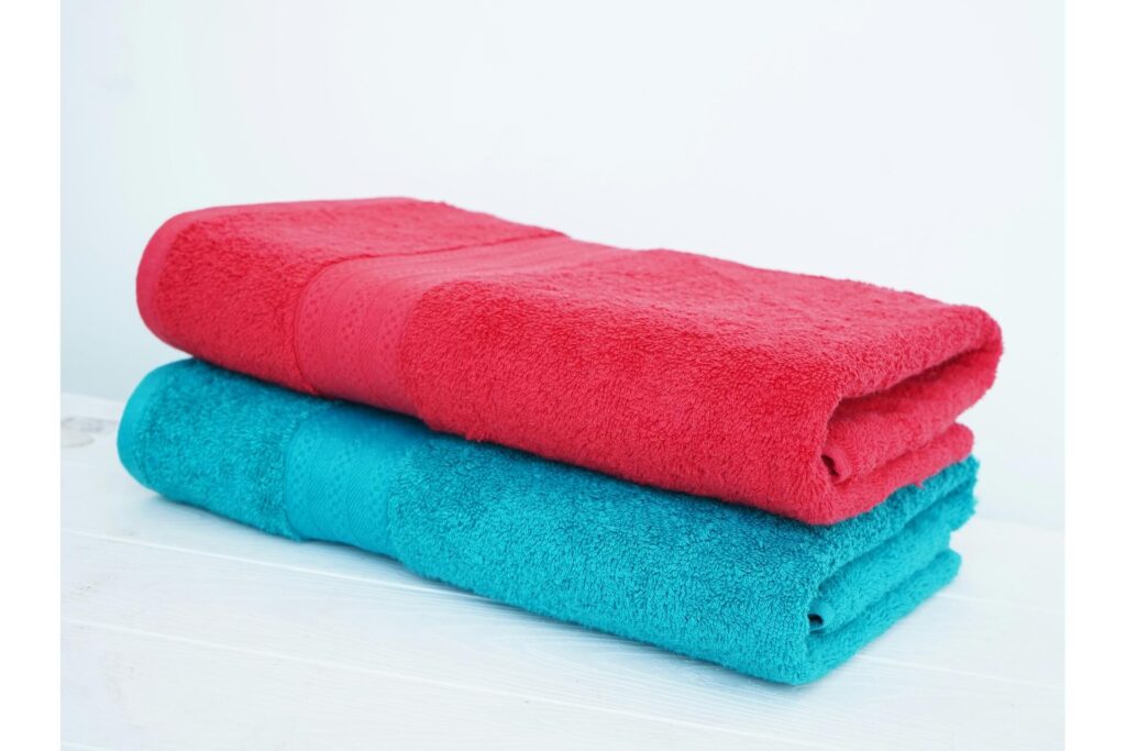 A folded red towel stacked on a folded blue one.