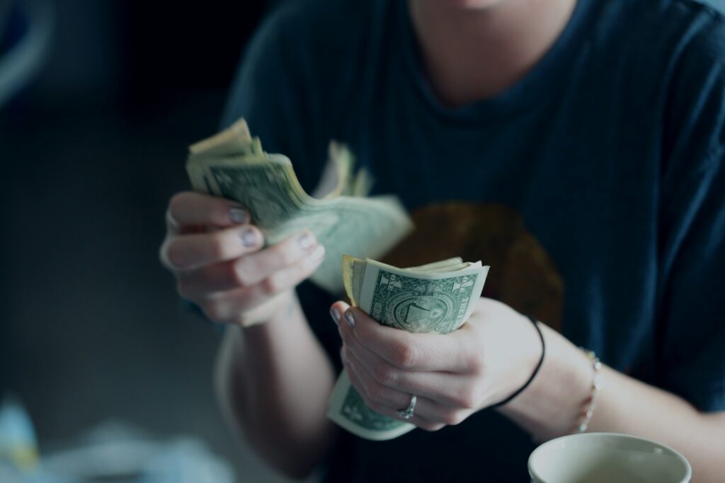 Person counting dollar bills by hand.