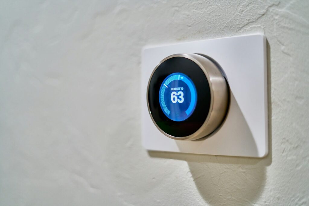 Gray Nest thermostat displaying a 63°F temperature