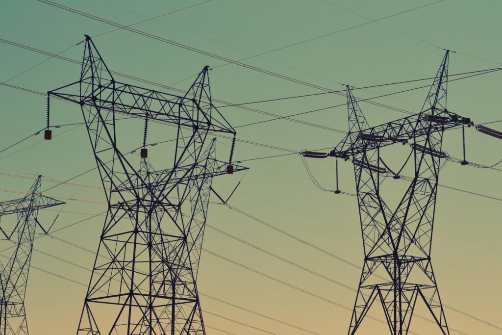 electricity pylons with cables and blue sky
