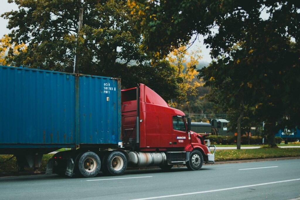 red truck with blue container on road