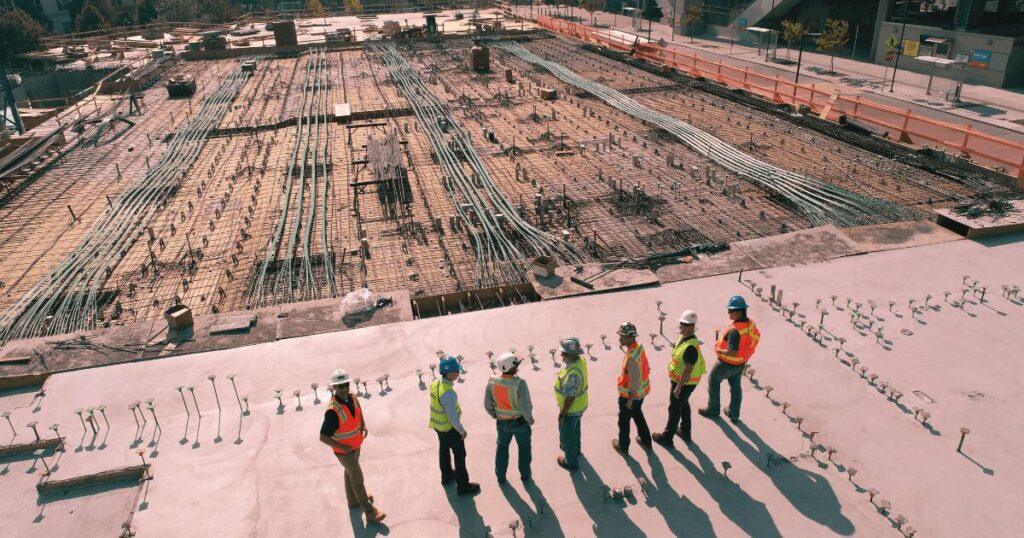 A deconstruction site with workers superivising the building