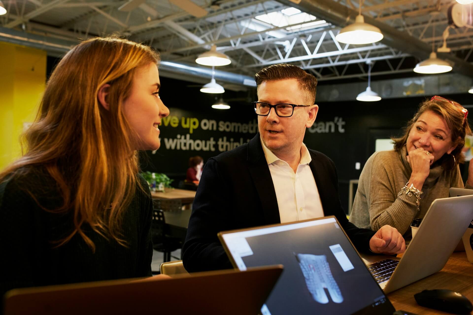 A male real estate agent speaking with two potential clients.