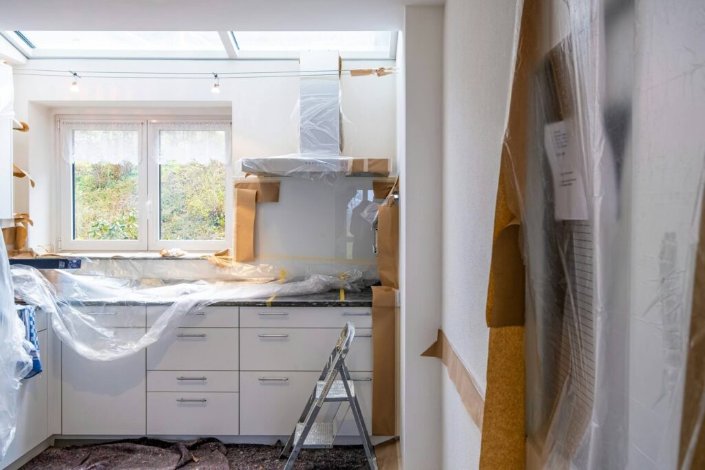 A kitchen under construction, with surfaces covered in plastic.