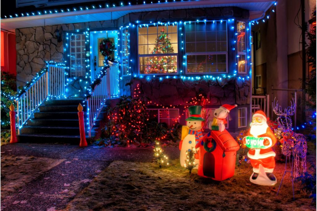 The facade of a house with plenty of outdoor holiday lights and lighted Christmas decorations.