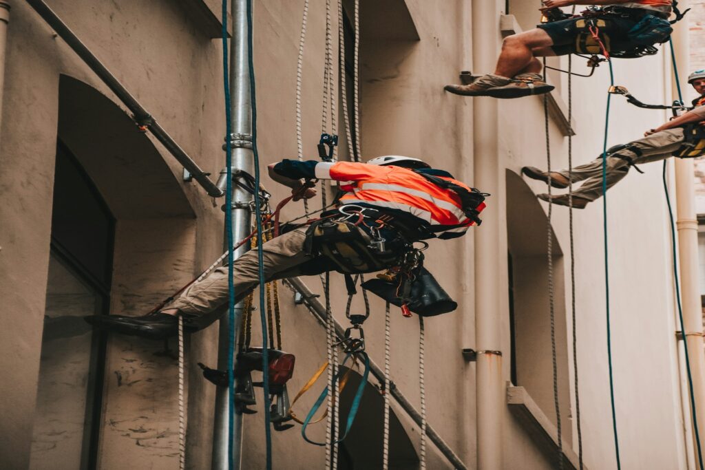 Workers using harnesses to promote construction safety.