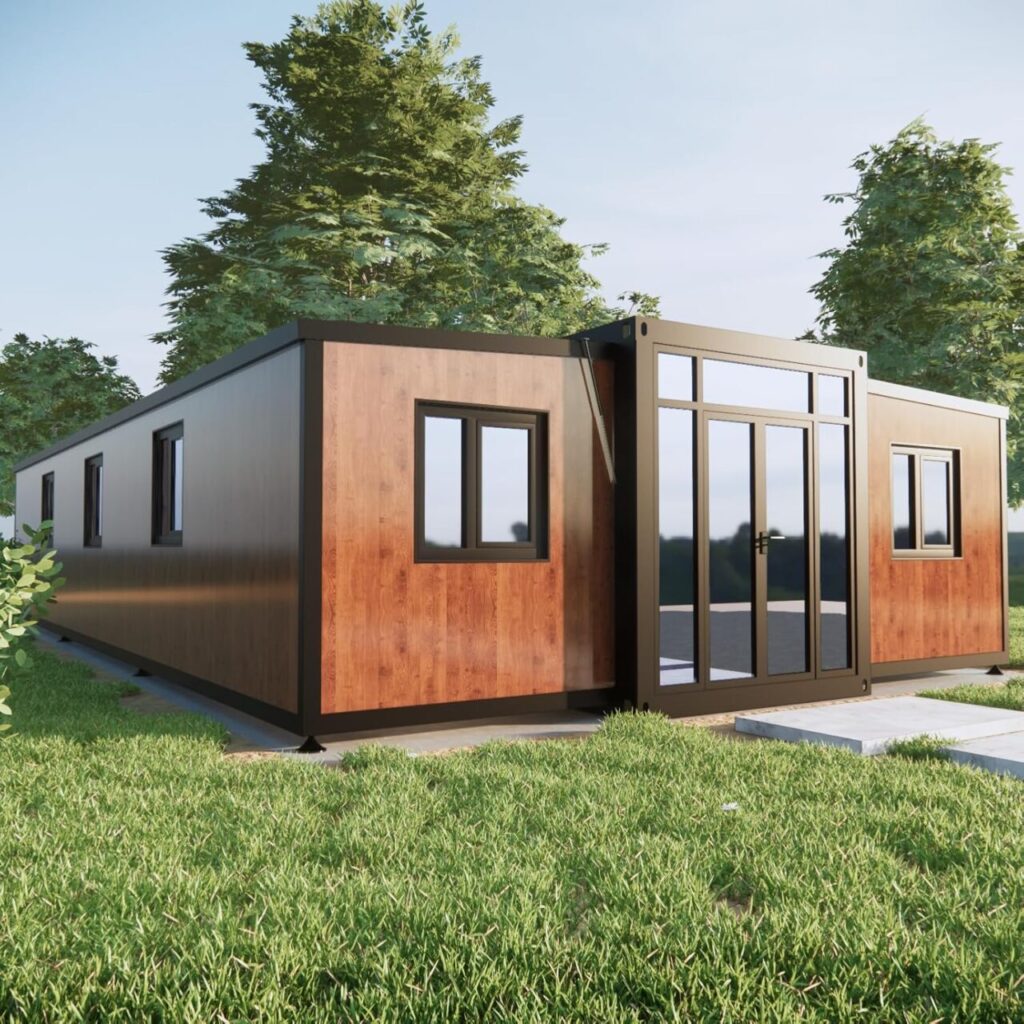 A rectangular, single-story metal home sits on a patch of grass. It has metal siding that looks like wood and a metal front door full of windows.