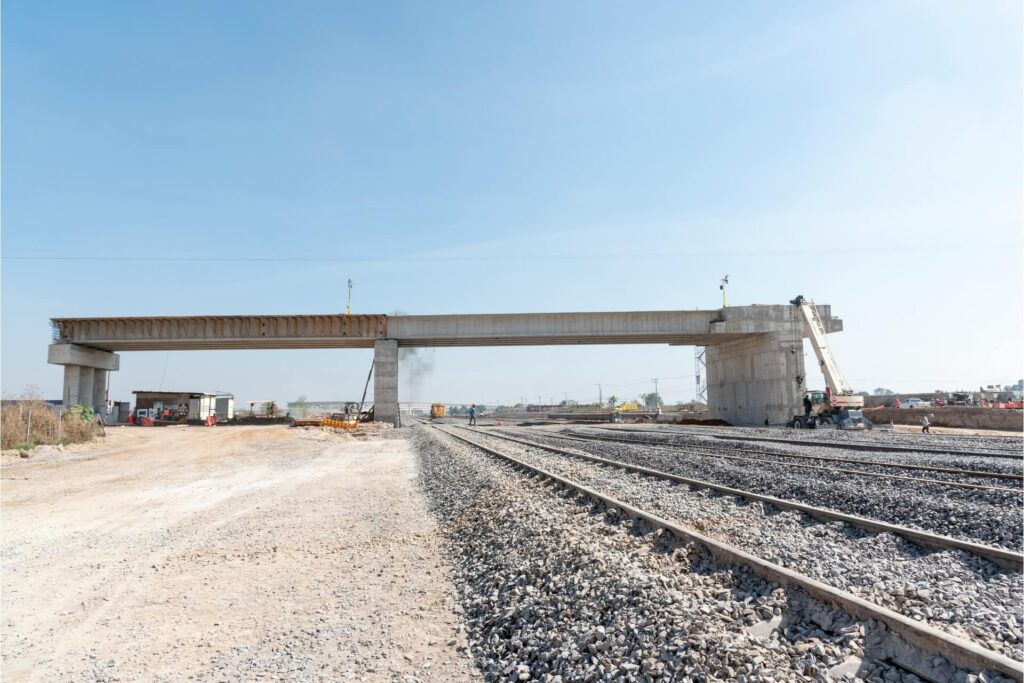 A road bridge under construction over a railroad.