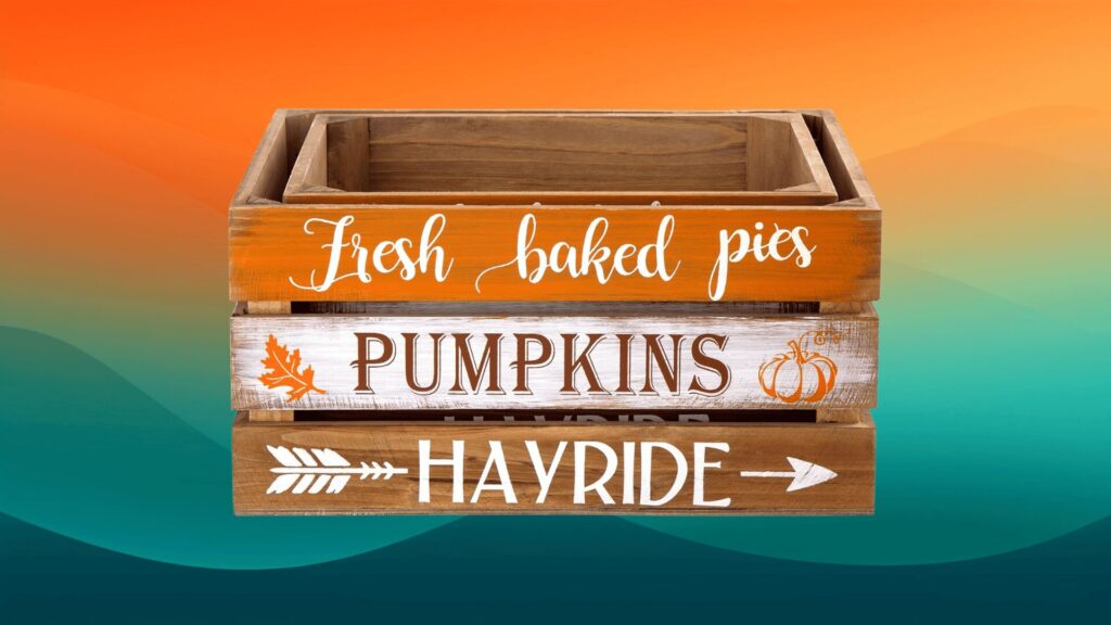 orange, white, and brown wooden basket that has says "fresh baked pies," "pumpkins," and "hayride" on it in front of an orange and teal background