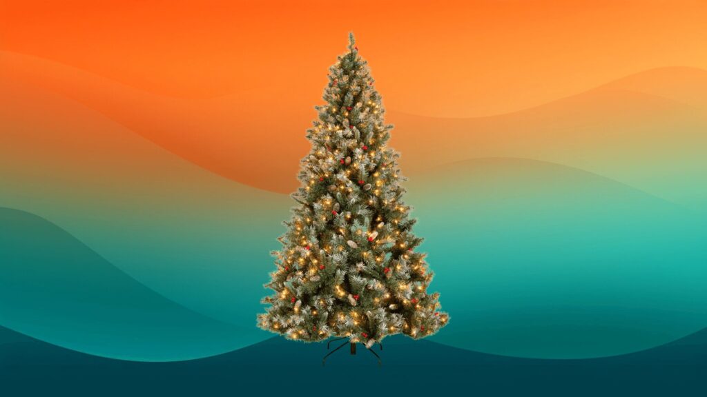 pre-lit Christmas tree with acorns and berries in front of an orange and teal background