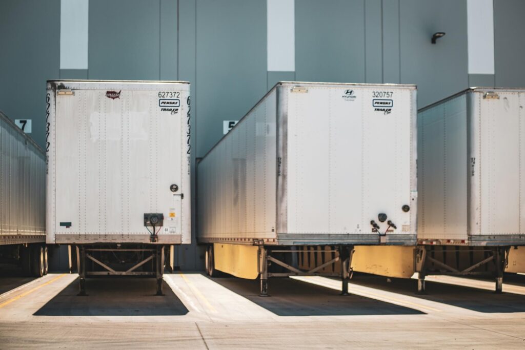 Shipping containers carrying aluminum siding at a loading dock.