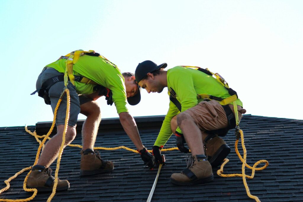 Part of roofing safety requires crew members wear a harness, which prevents them from falling from the roof entirely.