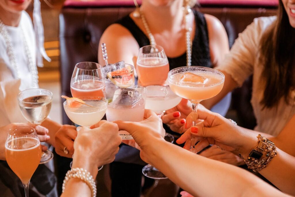 A group of women raising a toast with different cocktails
