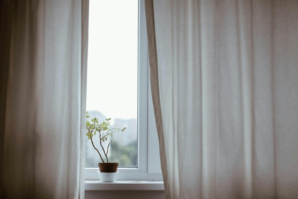 A curtain blown by the wind entering through a drafty window