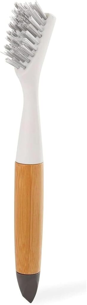 A gray wire bristle brush with a white tip and wooden handle sits against a white background.