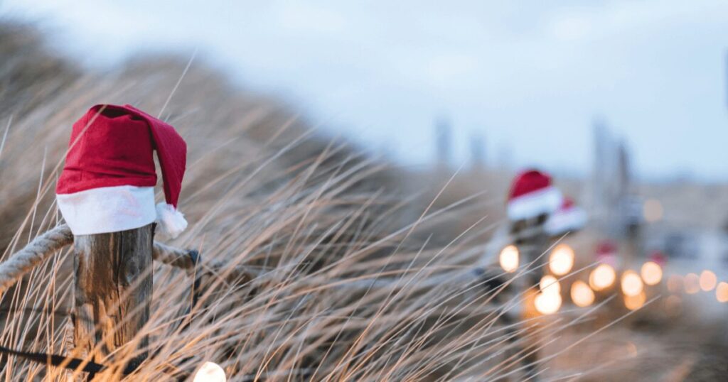 Christmas hats on top of a fence.
