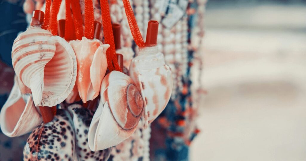 Seashells hanging from red string.