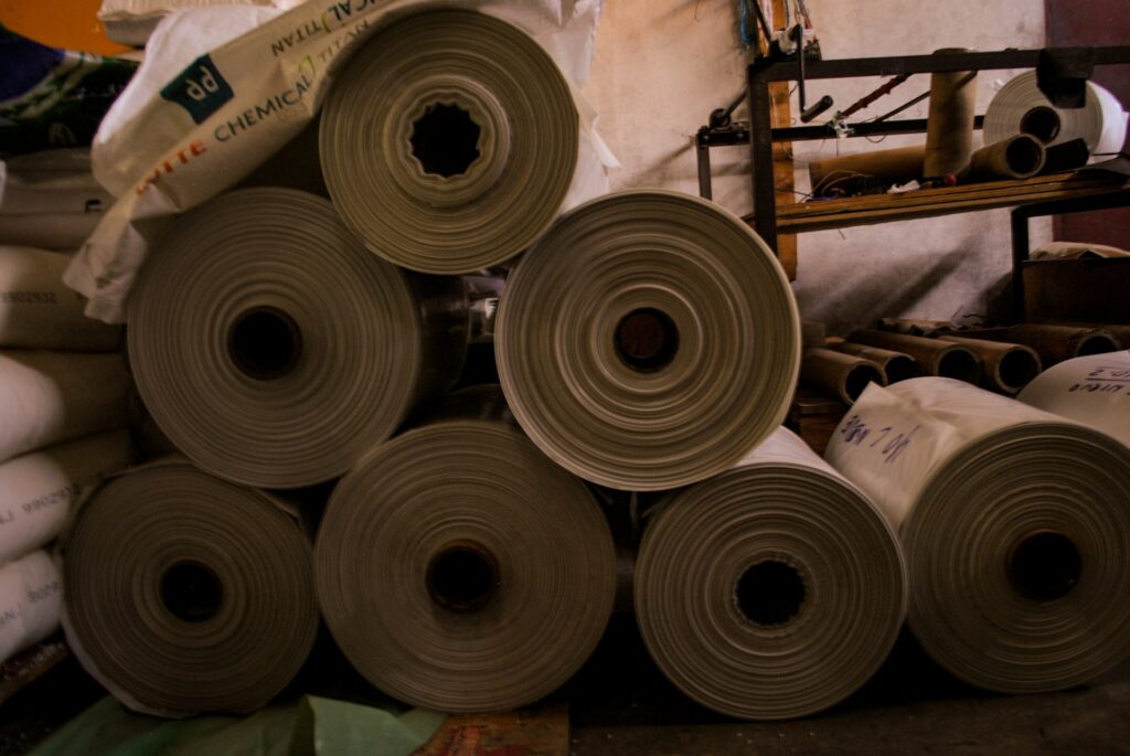 Sheets of white plastic are rolled up and waiting for a crawl space encapsulation project.
