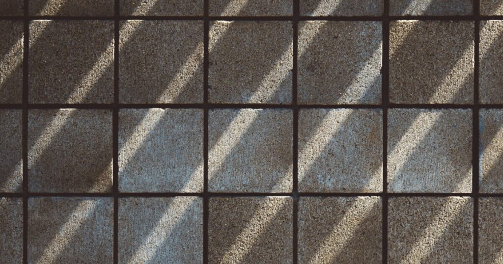 Concrete floor with square tile pattern.