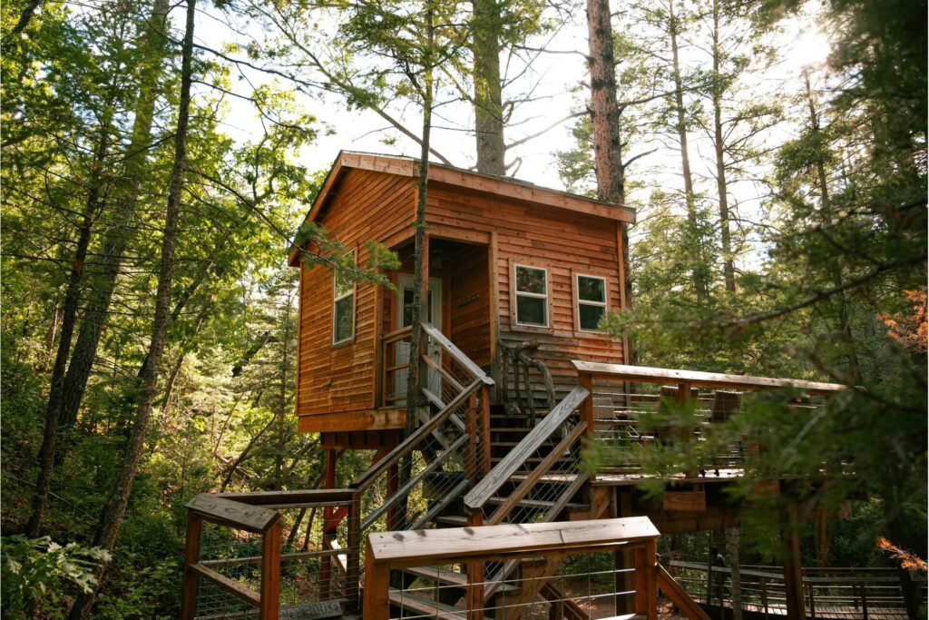 A rustic tree house with stairs and railings