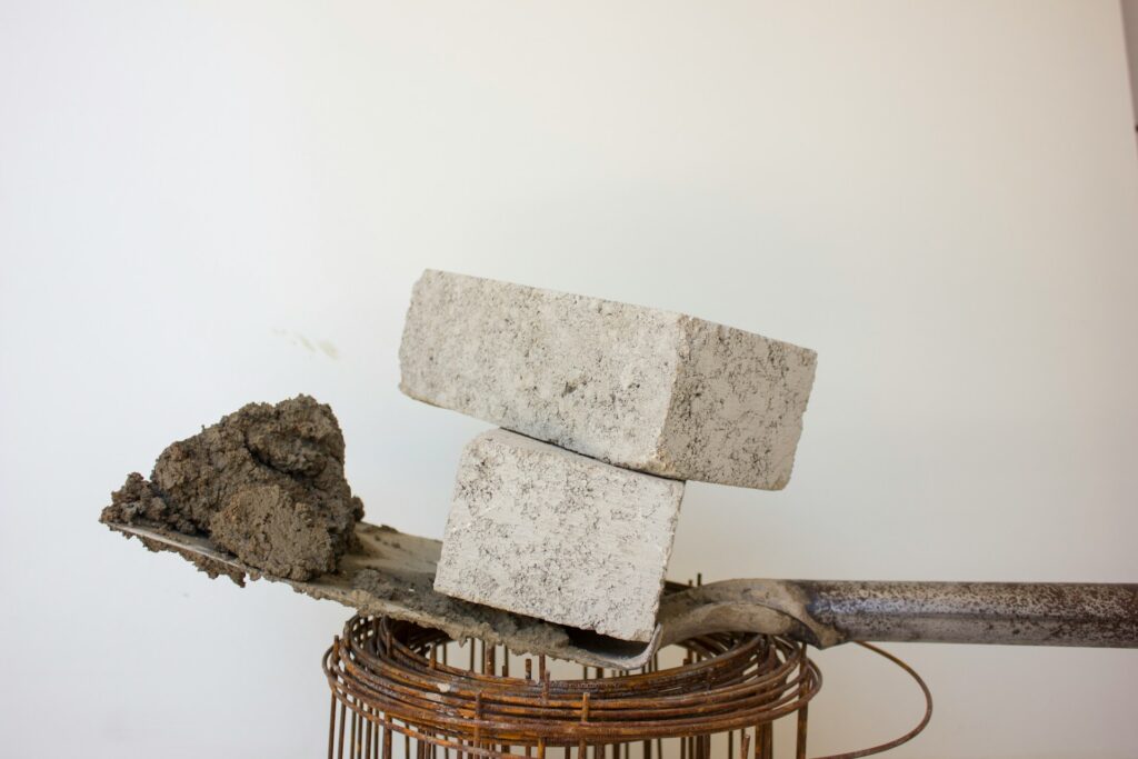 Two concrete bricks on a spade of cement.