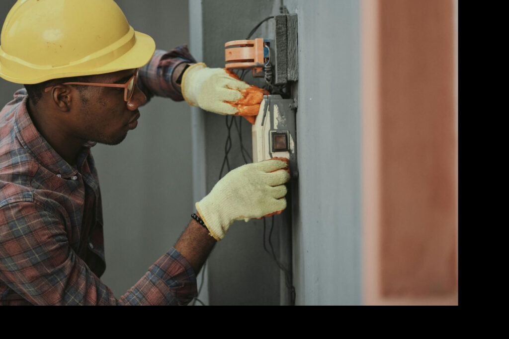 A young man wearing a hard hat and gloves during a construction training session