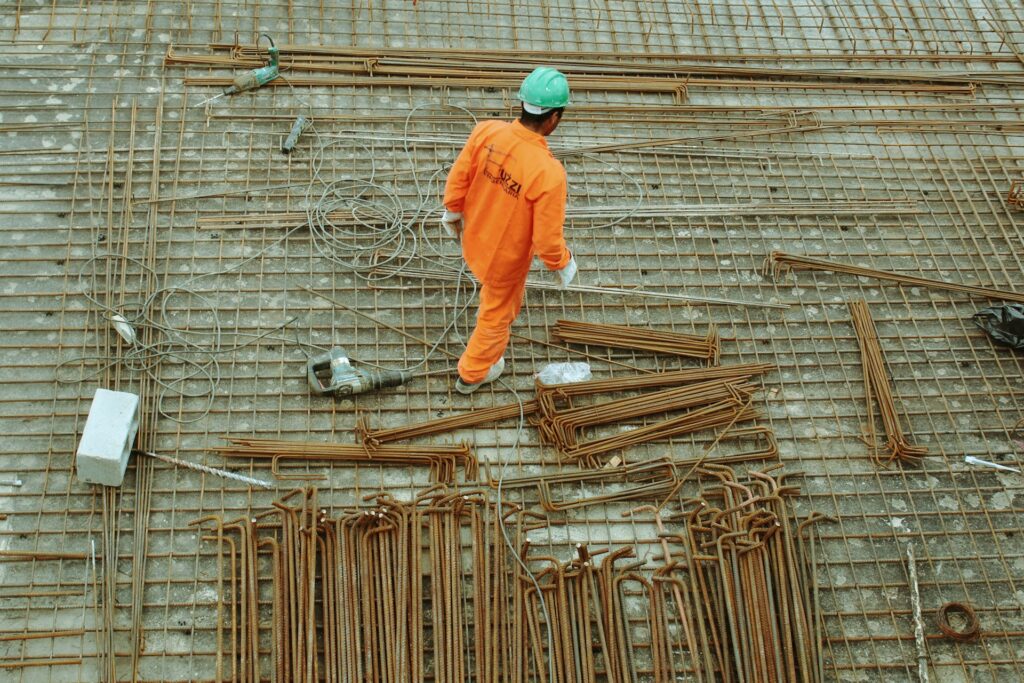 A builder at a construction site with green concrete.