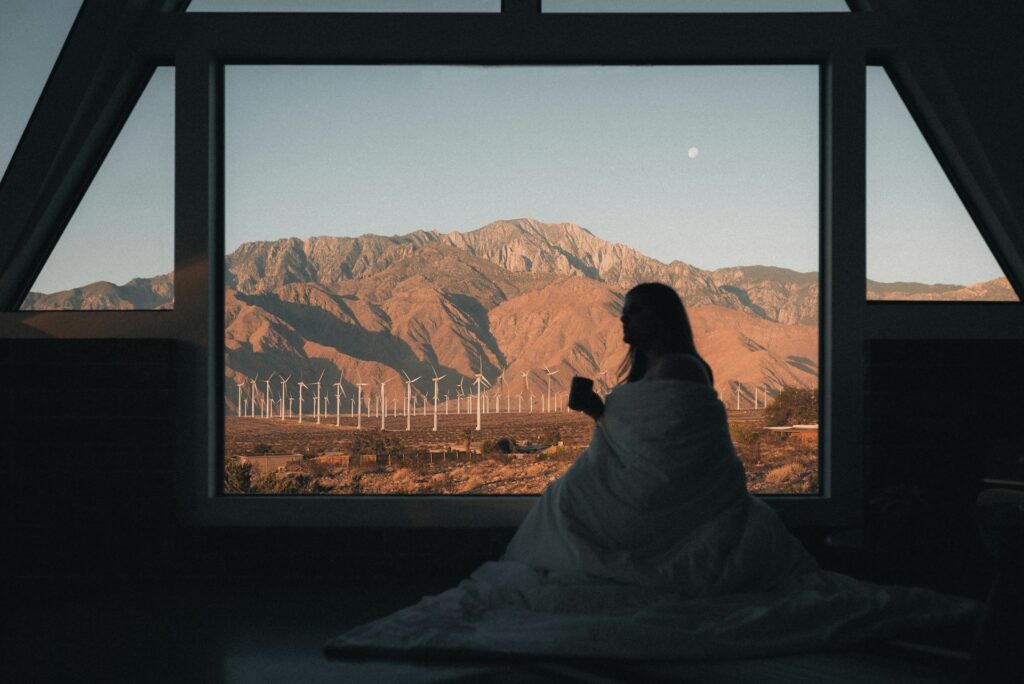 A woman enjoying a cup of coffee with a mountain view.