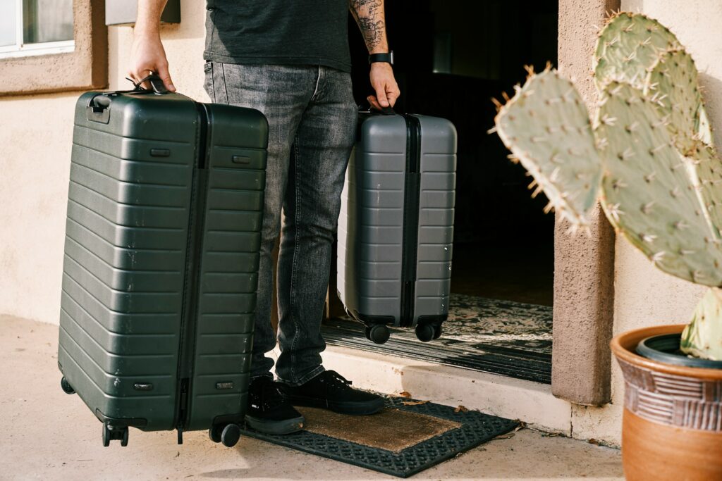 A man holding suitcases at his Airbnb.