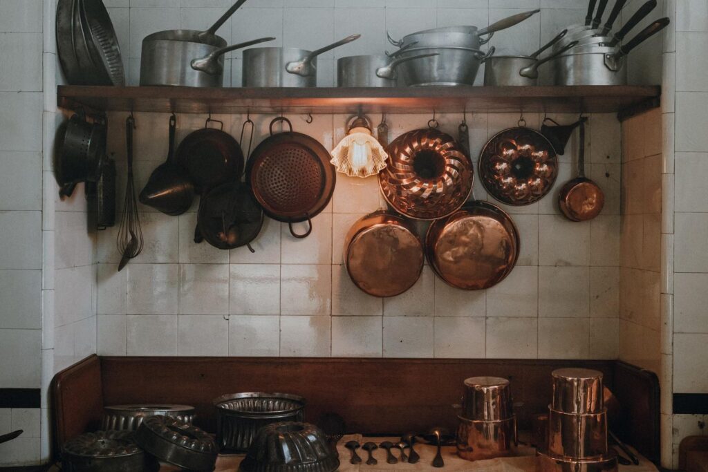 brass pots and pans hanging above kitchen counter