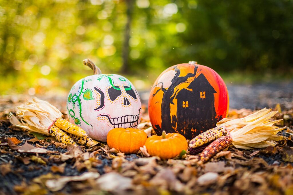Two Halloween-themed painted pumpkins