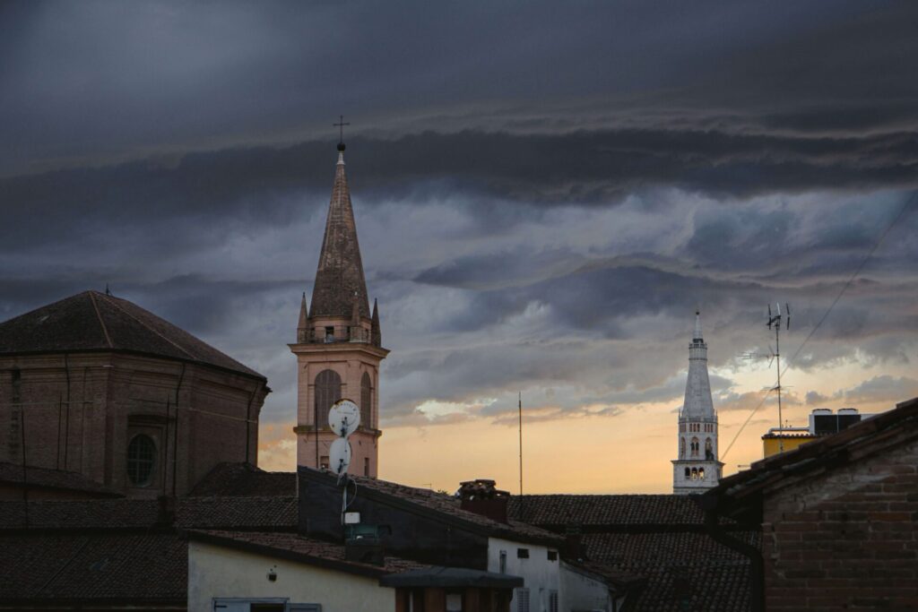 A clock tower over a cloudy city 