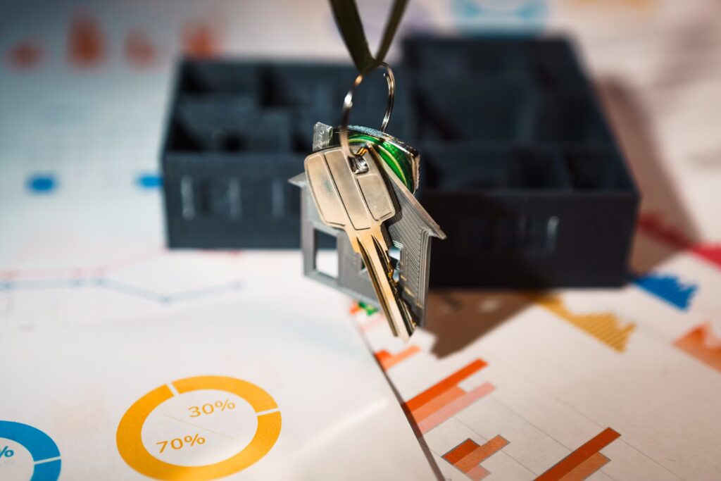 Keys floating over paperwork and house model