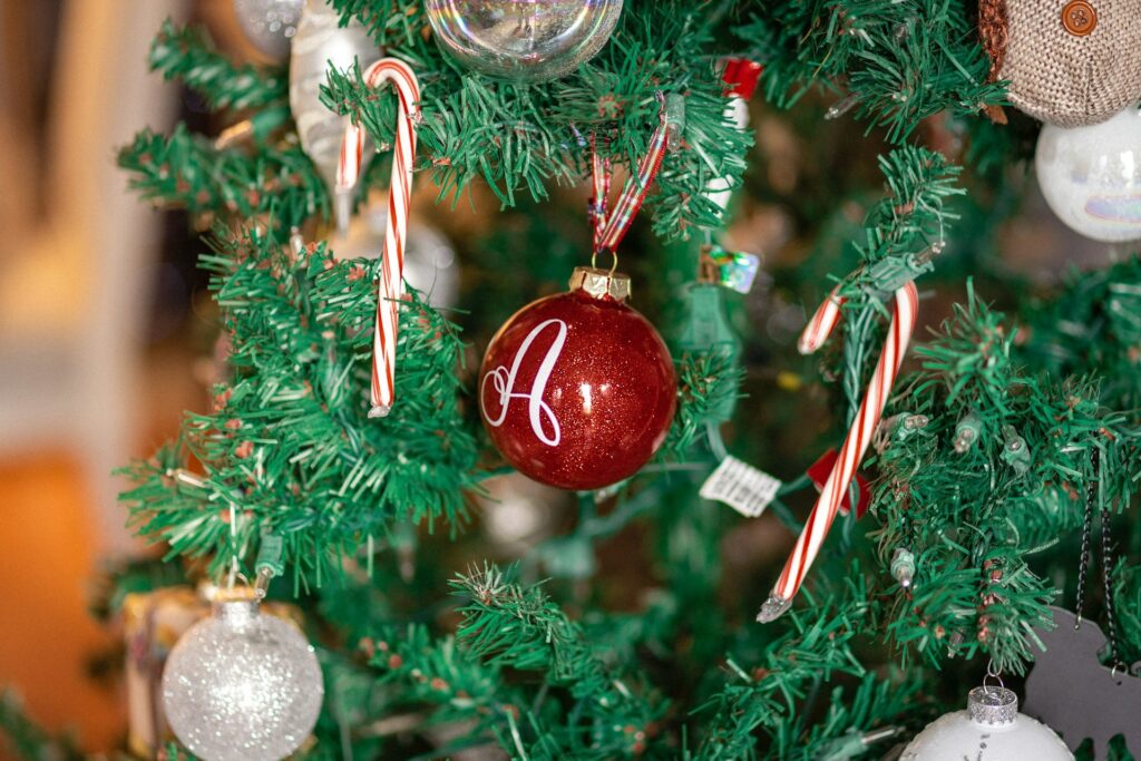 Candy canes and red ornaments hanging from tree