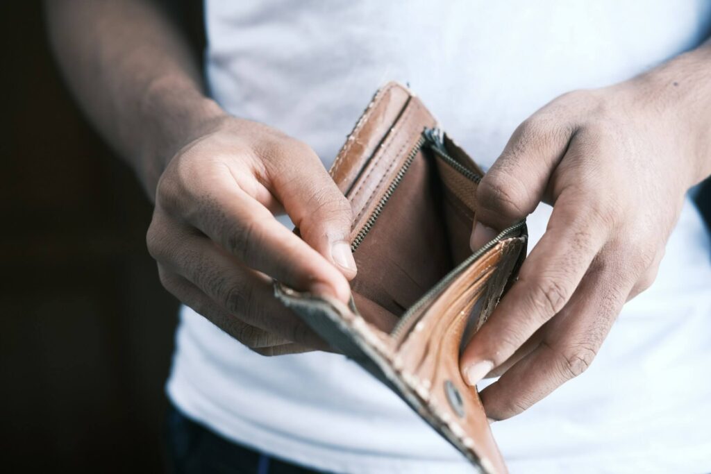 A person holding an empty worn-out wallet