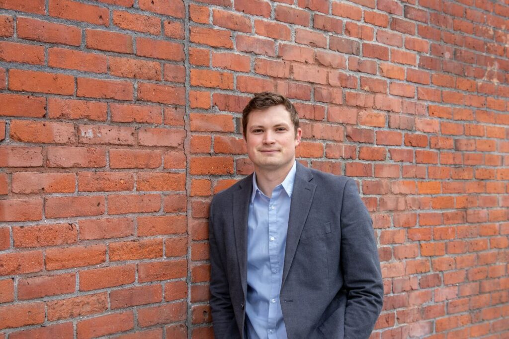 A Realtor standing next to a brick wall