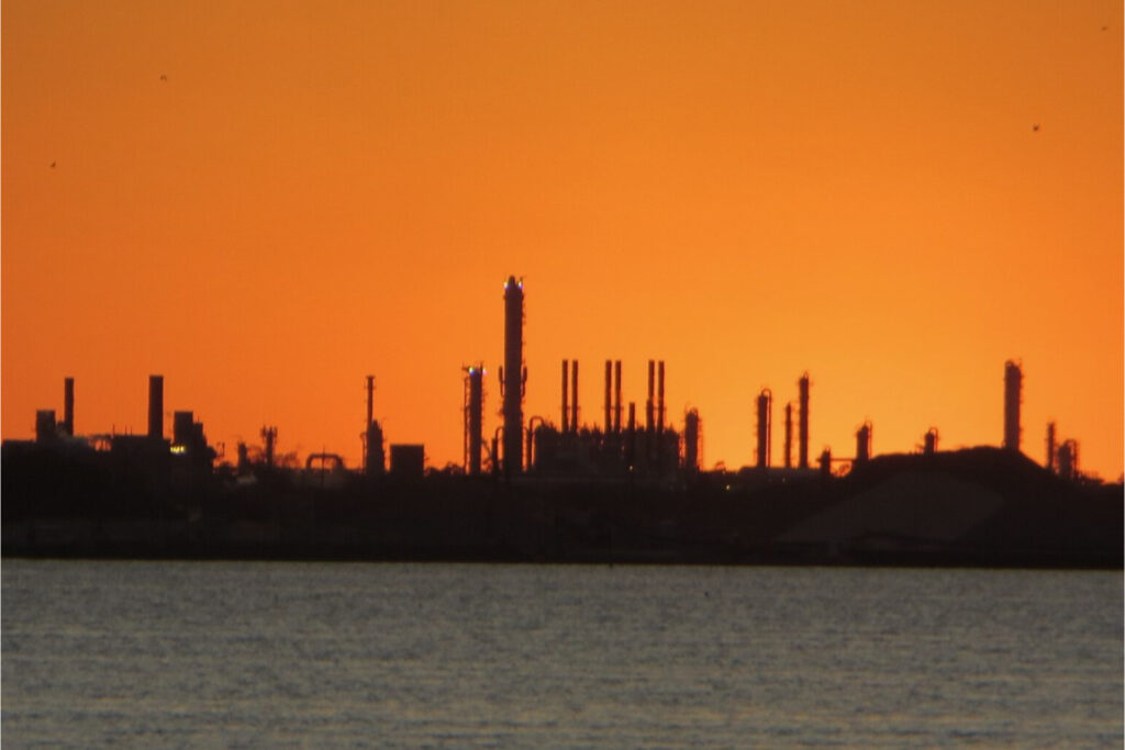 View of Lake Charles industry in orange sunset from across water