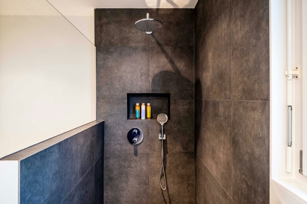 The key to maximizing this small bathroom walk-in shower idea is to ensure your niche has room for your bath products.