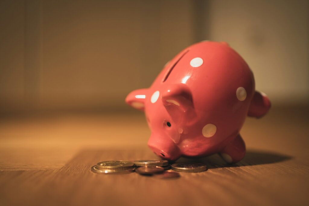 A piggy bank with coins around it